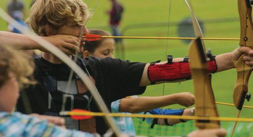 summer school students practising archery